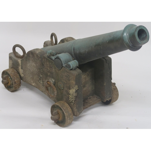 66 - A BRONZE CANNON ON WOODEN FRAME WITH CAST IRON WHEELS