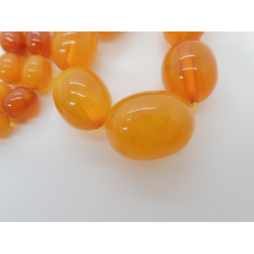 507 - TWO STRINGS OF AMBER BEADS