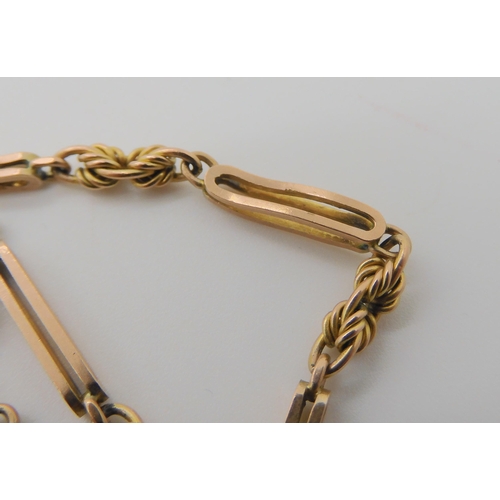 527 - A 9CT GOLD PIERCED BATON AND FANCY LINK GUARD CHAIN