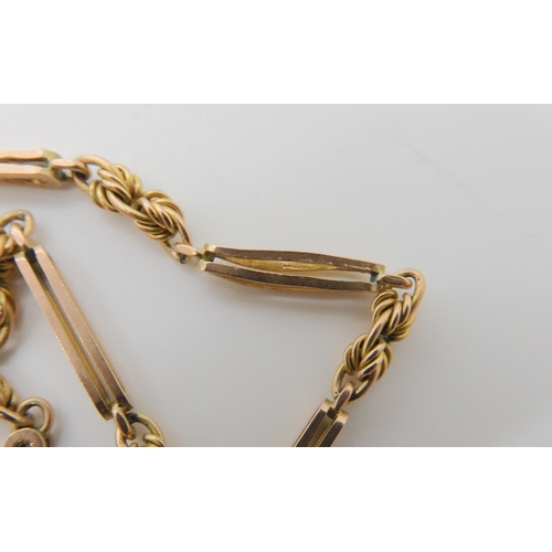 527 - A 9CT GOLD PIERCED BATON AND FANCY LINK GUARD CHAIN