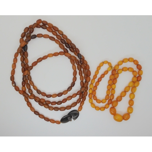 548 - A STRING OF AMBER BEADS AND A STRING OF HORN BEADS