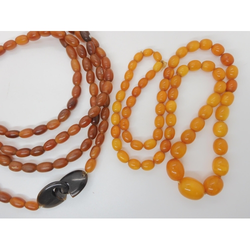 548 - A STRING OF AMBER BEADS AND A STRING OF HORN BEADS