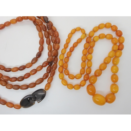 548 - A STRING OF AMBER BEADS AND A STRING OF HORN BEADS