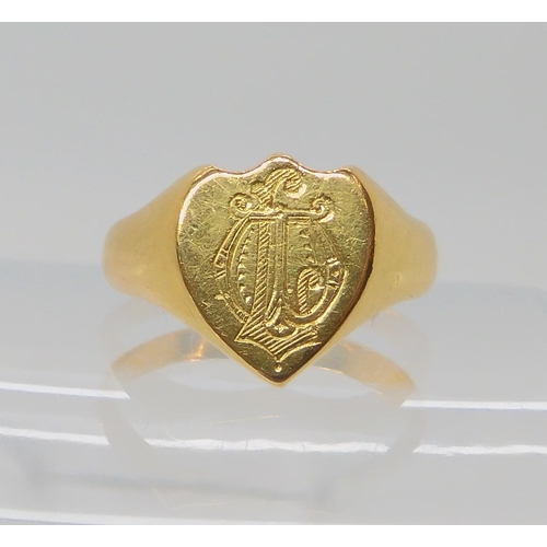 551 - A BRIGHT YELLOW METAL SHIELD SHAPED SIGNET RING