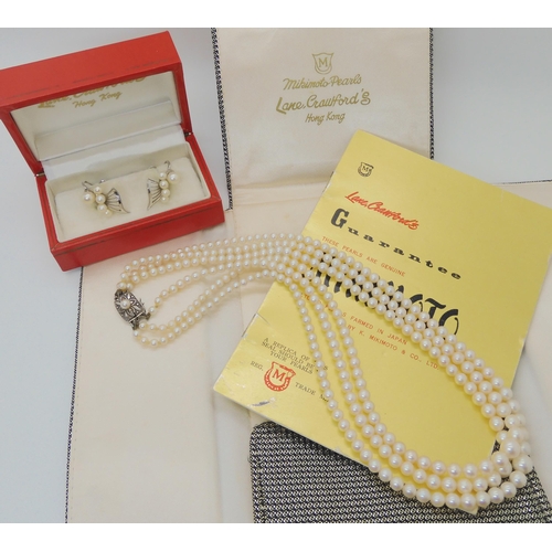 577 - A THREE STRAND OF MIKIMOTO PEARLS AND EARRINGS