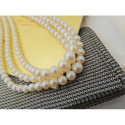 577 - A THREE STRAND OF MIKIMOTO PEARLS AND EARRINGS