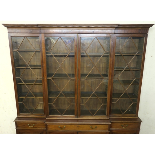 1 - A MAHOGANY BREAKFRONT BOOKCASE the dentil cornice above four astragal doors  encclosing shelves and ... 