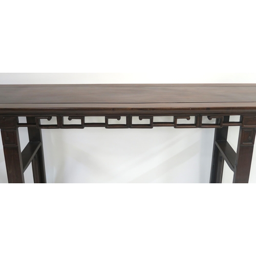 2 - A CHINESE HARDWOOD ALTER TABLE with carved and pierced key pattern frieze set on squared legs inset ... 