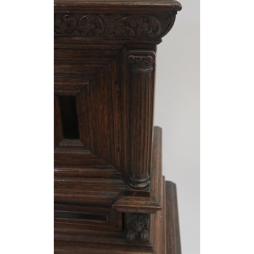 4 - A CONTINENTAL OAK AND EBONY CABINET AND STAND with a panelled drawer applied with lion brackets abov... 
