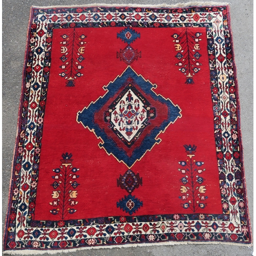 94 - A RED GROUND EASTERN RUG WITH CENTRAL MEDALLION