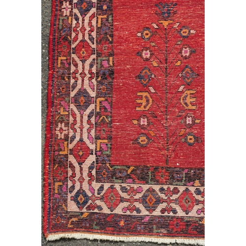 94 - A RED GROUND EASTERN RUG WITH CENTRAL MEDALLION