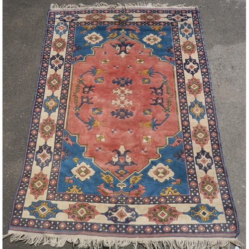 96 - A DARK PINK GROUND EASTERN RUG WITH BLUE SPANDRELS