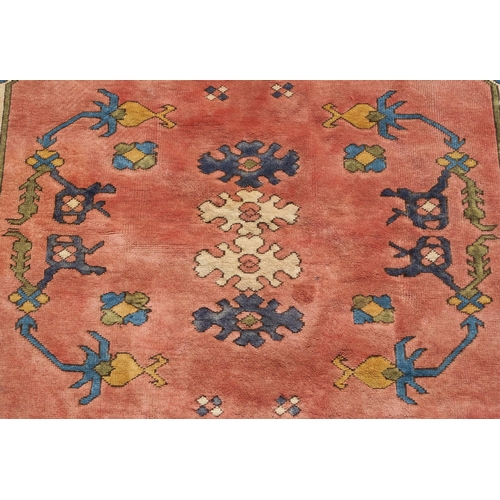 96 - A DARK PINK GROUND EASTERN RUG WITH BLUE SPANDRELS