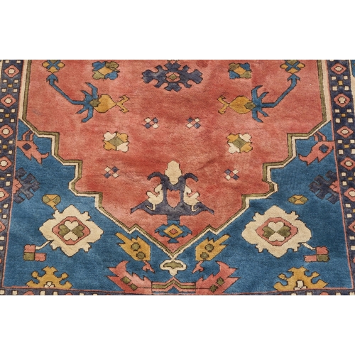 96 - A DARK PINK GROUND EASTERN RUG WITH BLUE SPANDRELS