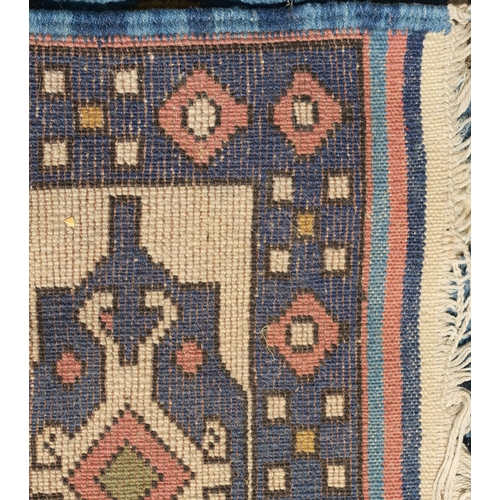 96 - A DARK PINK GROUND EASTERN RUG WITH BLUE SPANDRELS