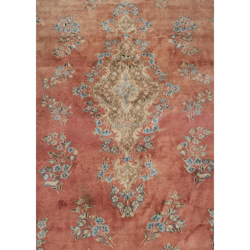 98 - A PINK GROUND RUG WITH CENTRAL MEDALLION