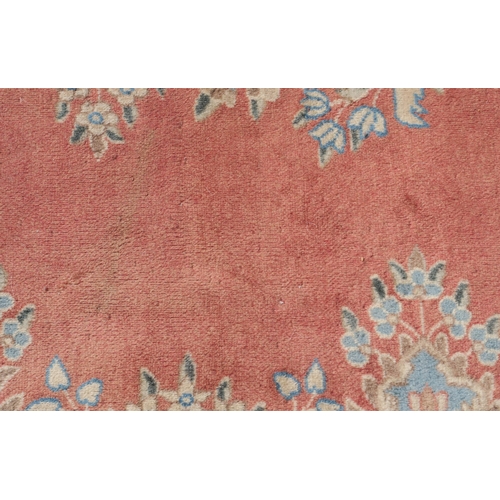 98 - A PINK GROUND RUG WITH CENTRAL MEDALLION