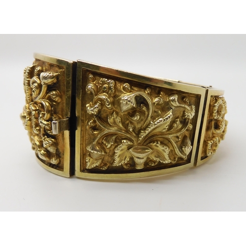 522 - A GILDED WHITE METAL REPOUSSE INDIAN BANGLE