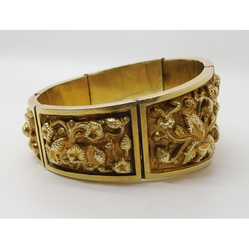 522 - A GILDED WHITE METAL REPOUSSE INDIAN BANGLE