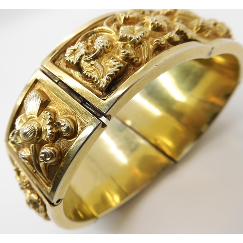 522 - A GILDED WHITE METAL REPOUSSE INDIAN BANGLE