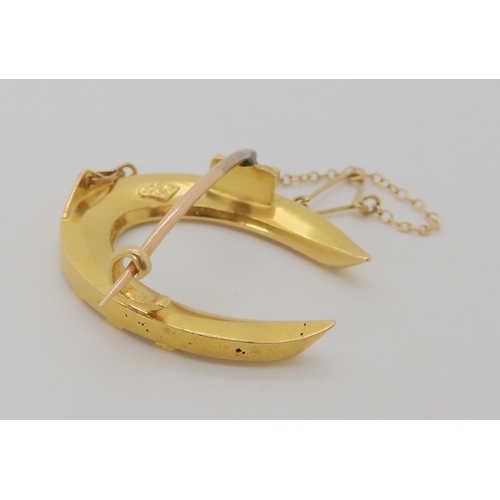 529 - A BRIGHT YELLOW METAL HORSESHOE BROOCH