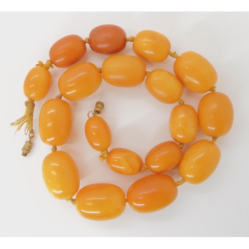 549 - A STRING OF YELLOW AMBER BEADS