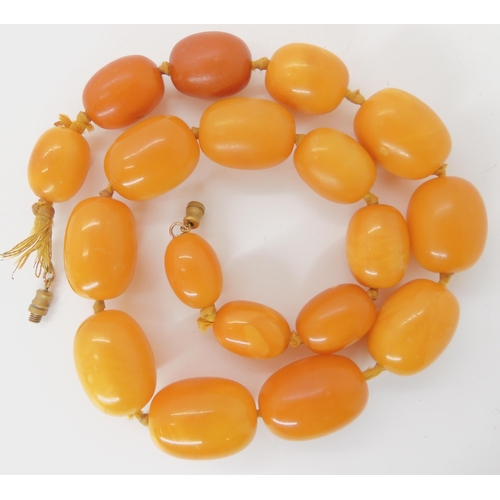 549 - A STRING OF YELLOW AMBER BEADS