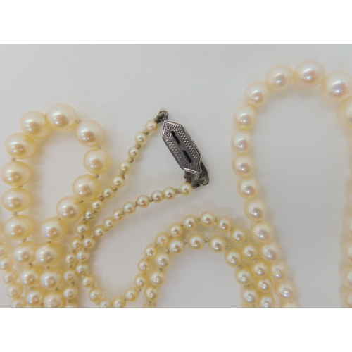 566 - TWO STRINGS OF PEARLS WITH DECORATIVE CLASPS