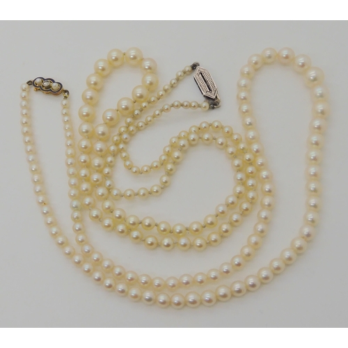 566 - TWO STRINGS OF PEARLS WITH DECORATIVE CLASPS