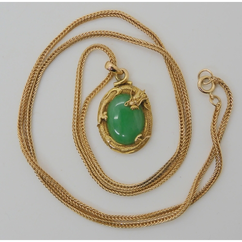 570 - A CHINESE GREEN HARDSTONE AND DRAGON PENDANT