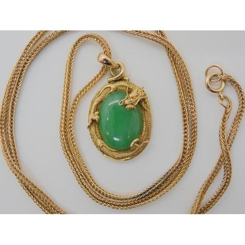 570 - A CHINESE GREEN HARDSTONE AND DRAGON PENDANT