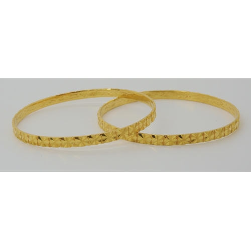 587 - TWO INDIAN GOLD BANGLES