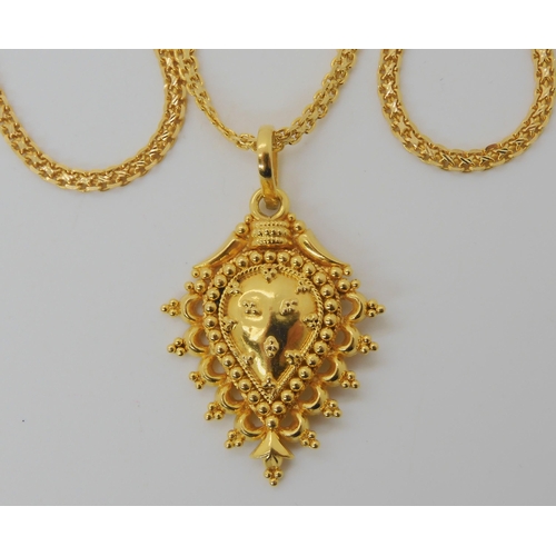 602 - A BRIGHT YELLOW METAL INDIAN PAISLEY SHAPED PENDANT AND CHAIN