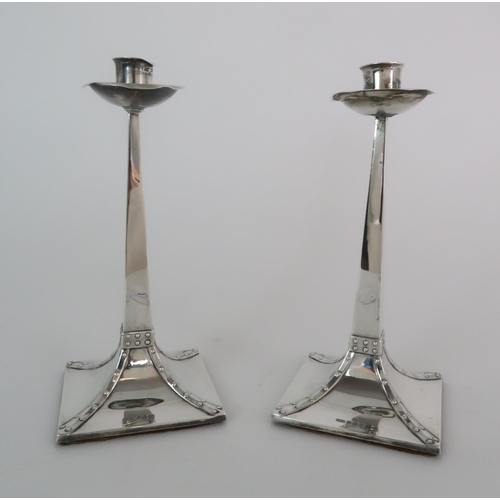 719 - A PAIR OF ARTS AND CRAFTS SILVER CANDLESTICKS