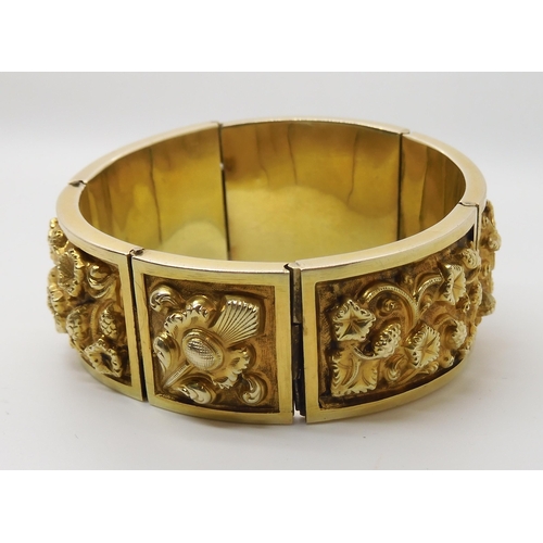 522 - A GILDED WHITE METAL REPOUSSE INDIAN BANGLE