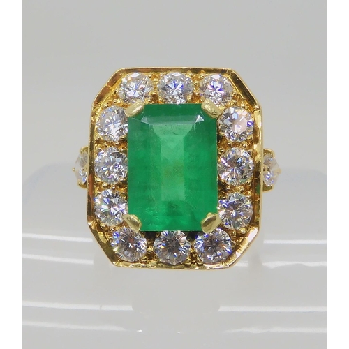 557 - AN 18CT GOLD EMERALD AND DIAMOND DRESS RING