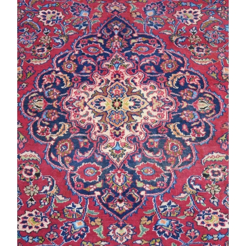 100 - A RED GROUND MESHED RUG