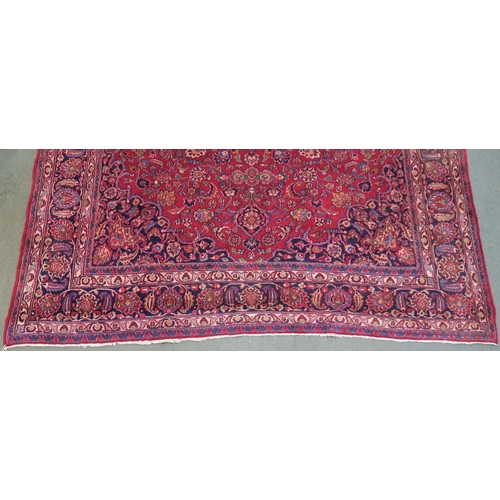 100 - A RED GROUND MESHED RUG