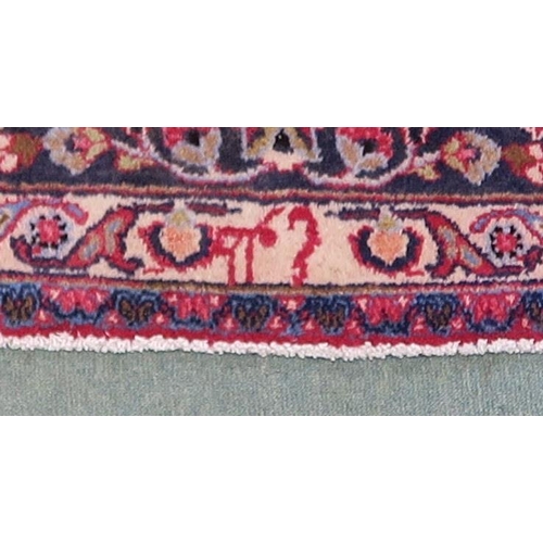 100 - A RED GROUND MESHED RUG