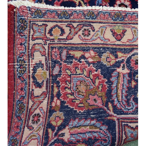 100 - A RED GROUND MESHED RUG