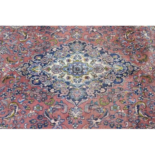 94 - A LARGE WASHED RED GROUND KESHAN RUG