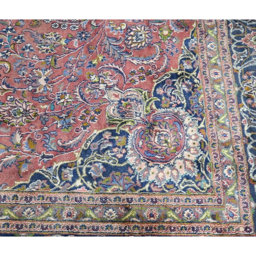 94 - A LARGE WASHED RED GROUND KESHAN RUG