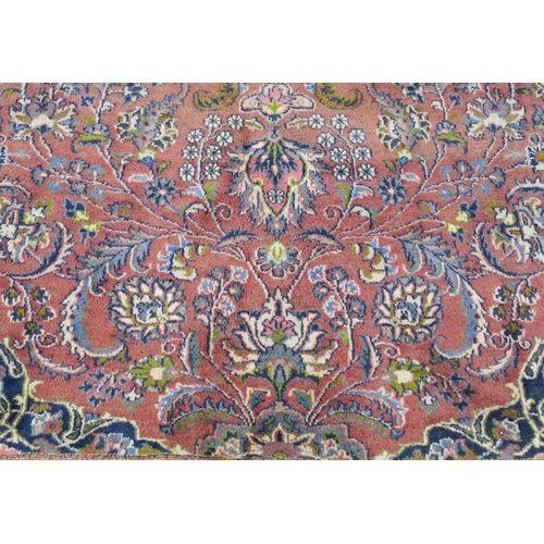 94 - A LARGE WASHED RED GROUND KESHAN RUG