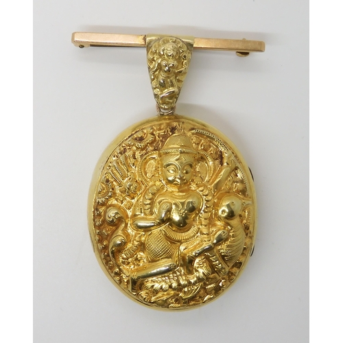 636 - A YELLOW METAL INDIAN LOCKET DEPICTING THE HINDU GODDESS SARASWATI