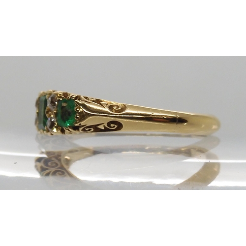 638 - AN 18CT GOLD EMERALD AND DIAMOND RING IN A SCROLLED MOUNT