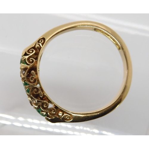 638 - AN 18CT GOLD EMERALD AND DIAMOND RING IN A SCROLLED MOUNT