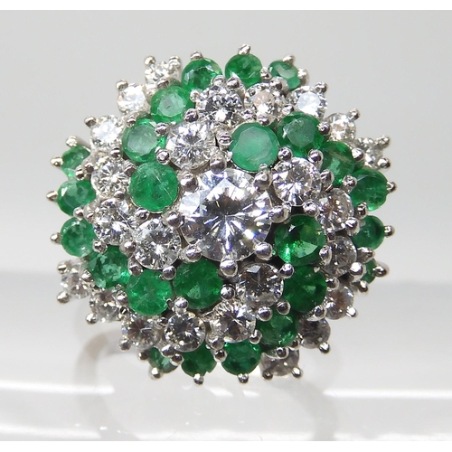 675 - AN 18CT GOLD EMERALD AND DIAMOND CLUSTER RING