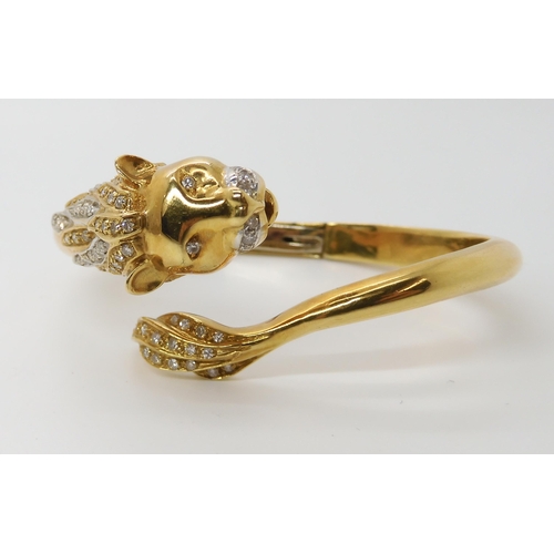 676 - AN 18CT GOLD AND DIAMOND HINGED LION BANGLE