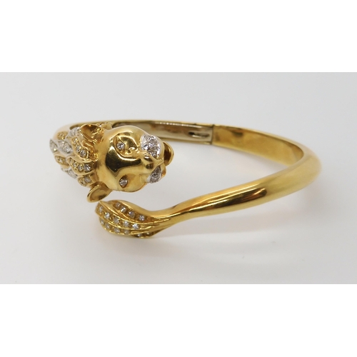 676 - AN 18CT GOLD AND DIAMOND HINGED LION BANGLE