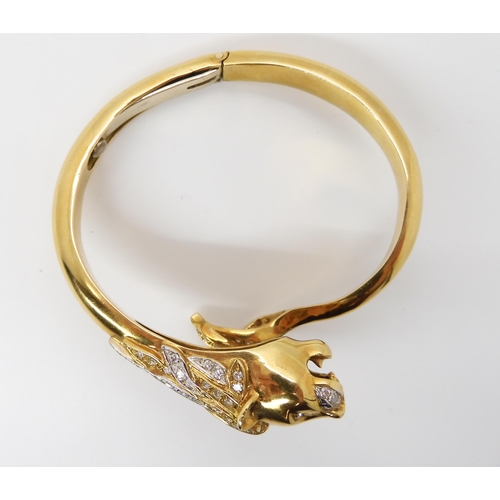 676 - AN 18CT GOLD AND DIAMOND HINGED LION BANGLE